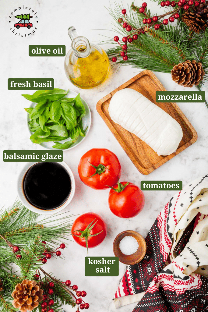 Ingredients for making caprese salad on a table, including tomatoes, basil, balsamic glaze, olive oil, and salt. 