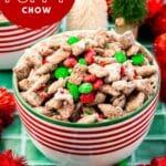 A bowl of Christmas puppy chow topped with M&Ms and holiday sprinkles with Christmas decor surrounding the bowl.