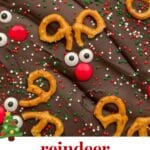 An overhead view of reindeer chocolate bark with semi-sweet chocolate melted in a rectangle and topped with pretzels, candy eye balls and red M&Ms to make the reindeer faces.