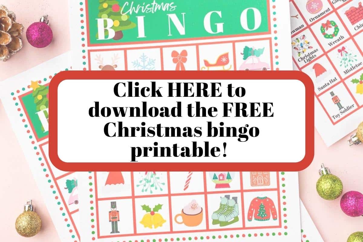 A printable Christmas Bingo card on a pink table with a text overlay that says "Click HERE to download the FREE Christmas Bingo Printable!" on the image.