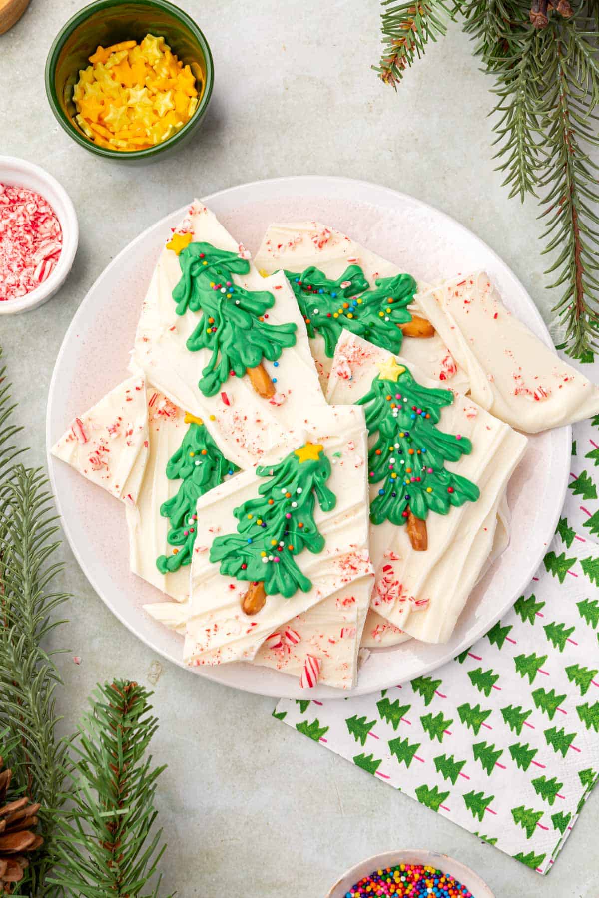 A plate of pieces of Christmas tree white chocolate peppermint bark.