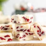A stack of three cranberry white chocolate fudge with more fudge leaning on I.