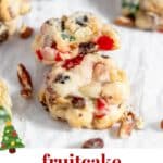 Two fruitcake cookies staggered on top of each other on a piece of parchment paper with a text overlay over the image.
