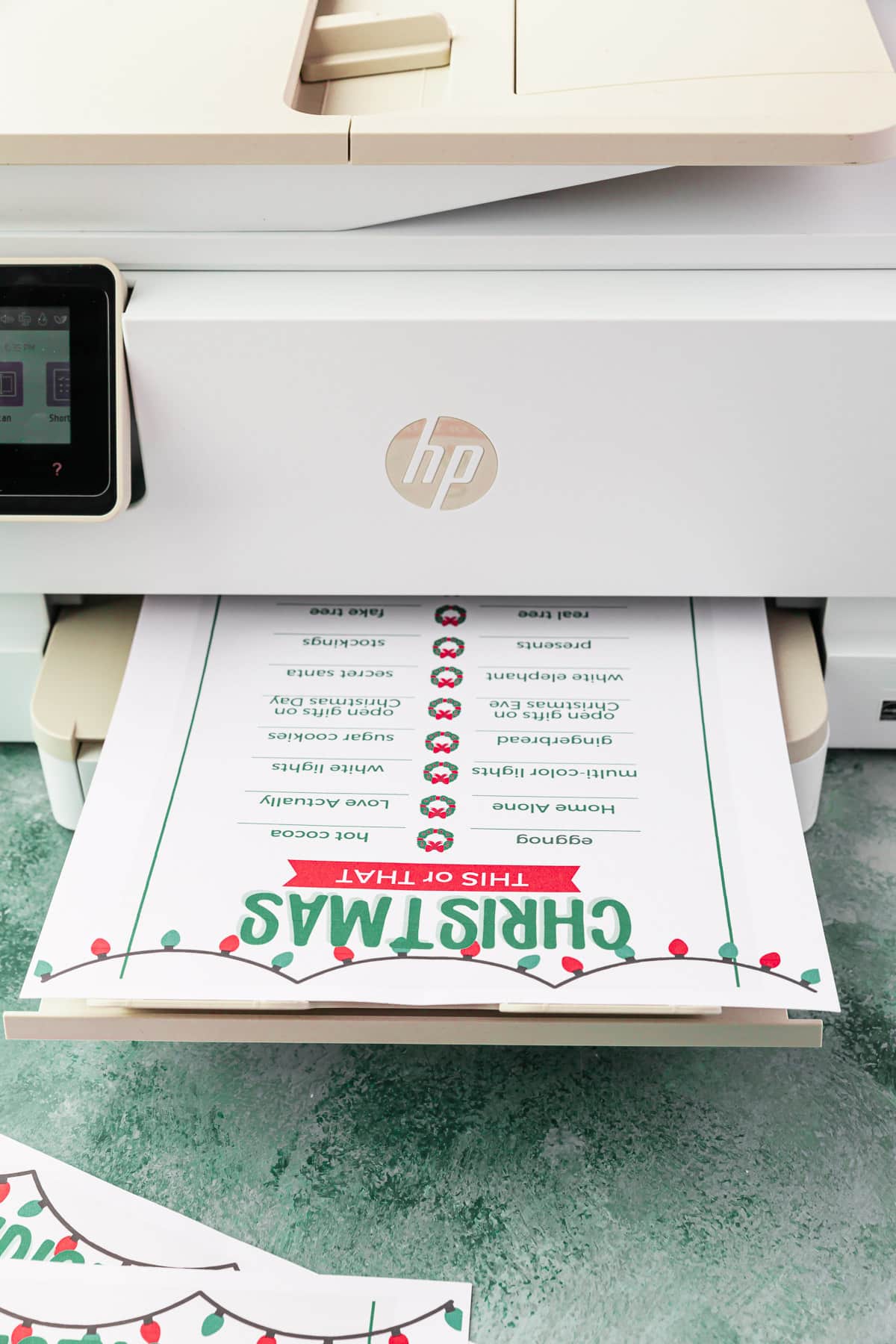 A page of a Christmas This or That printable being printed from a HP inkjet color printer.