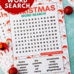 A printable Christmas word search page on a green background with red ornaments and Christmas trees surrounding it.