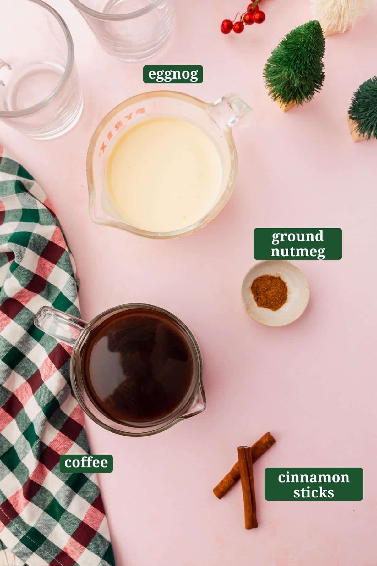 Ingredients in small bowls to make eggnog coffee, including eggnog, coffee, nutmeg, and cinnamon sticks with a text overlay over each ingredient.