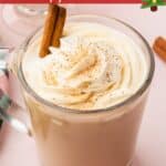 An eggnog coffee topped with a swirl of eggnog whipped cream, a sprinkle of nutmeg and a cinnamon stick.