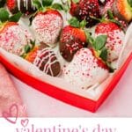 A red heart shaped box filled with Valentine's Day chocolate covered strawberries dipped in both white chocolate and dark chocolate and decorated with red and pink sprinkles.