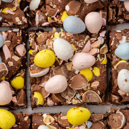 An overhead view of a closeup of Easter mini egg brownies cut into 9 pieces.