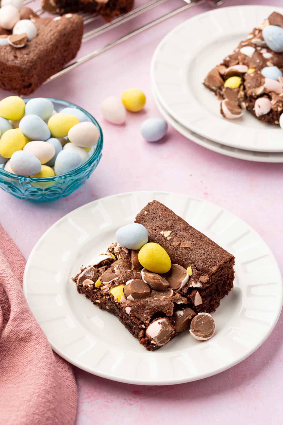 A single Easter brownie topped with mini chocolate eggs on a desert plate.
