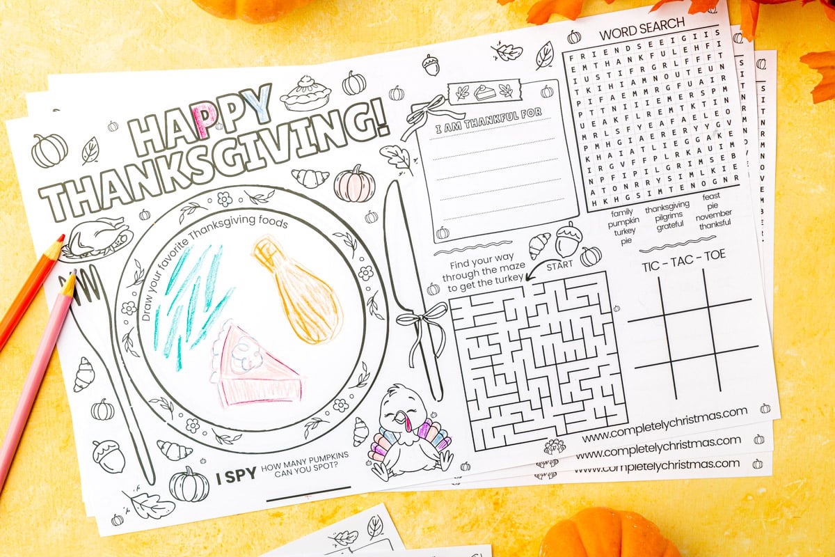 Legal size Thanksgiving placemat showing completed drawing section with colorful foods on plate, word search puzzle, "I am thankful for" section, turkey maze, and tic-tac-toe board.