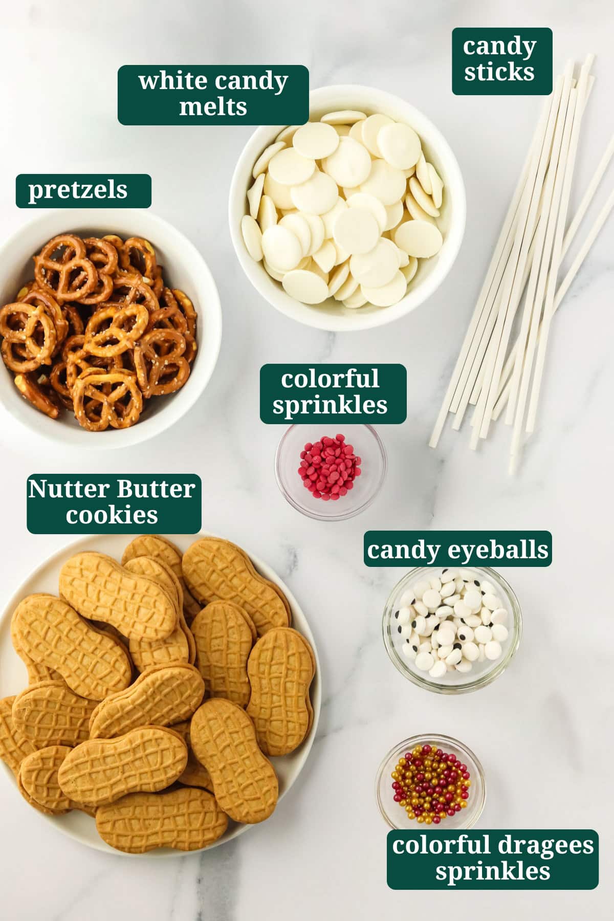 Ingredients for Nutter Butter Snowman cookies including Nutter Butters, white candy melts, pretzels, candy eyeballs, colorful sprinkles, and candy sticks.