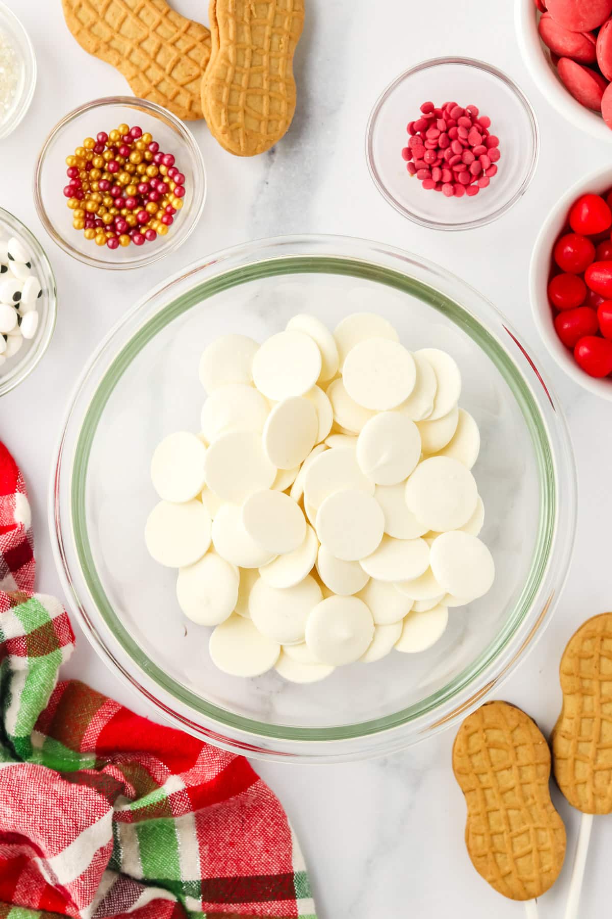 White candy melts in a glass bowl ready to be melted for Nutter Butter Snowman cookies.